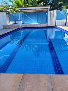 a large swimming pool with blue tiles on it at Cacha Pregos Vera Cruz - BA in Vera Cruz de Itaparica