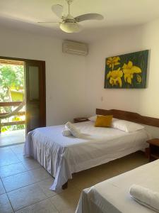 a bedroom with two beds and a ceiling fan at Pousada Sunset in Itacaré +17 photos