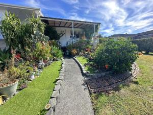 a garden with some plants and a house at sweet house in Auckland