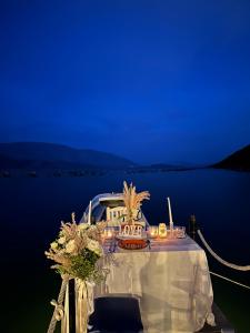a table with candles and flowers on top of a boat at The Mussel House in Ksamil