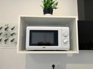 a microwave on a shelf with a potted plant at TherezAss Holiday in Calais