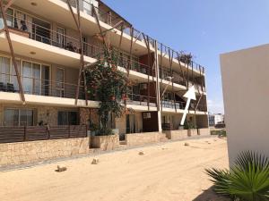a building on the beach with flowers on it at Ca Madeira - 2bedroom, Sea View & Wifi in Sal Rei