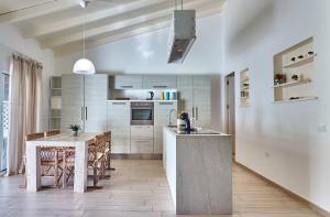 a kitchen with a table and a dining room at Beach Villa - By Bobbywashere in Santa Maria