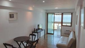 una sala de estar con una mesa y un sofá en Flat Residencial Praia da Barra, Piscina e Sauna - Frente Mar D68508, en Río de Janeiro