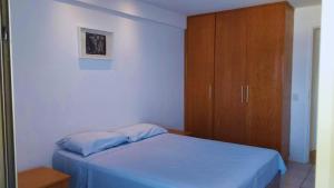 1 dormitorio con 1 cama azul y armario de madera en Flat Residencial Praia da Barra, Piscina e Sauna - Frente Mar D68508, en Río de Janeiro 25 fotos más