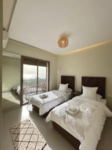 阿加迪尔Appartement vue océan的一间带两张床的卧室和一个阳台