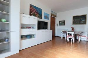 a living room with a television and a table with chairs at ModernShore - Garden Hideaway in Alba Adriatica