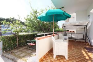 a patio with a table and an umbrella at ModernShore - Garden Hideaway in Alba Adriatica