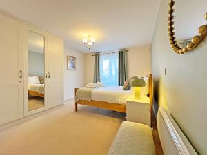 ウィンザーにあるPrime Windsor Location 3 Bedroom Apartment with Free Private Parkingのベッドと鏡のある寝室