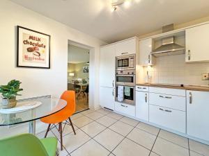 ウィンザーにあるPrime Windsor Location 3 Bedroom Apartment with Free Private Parkingの白いキャビネットとガラスのテーブル付きのキッチン