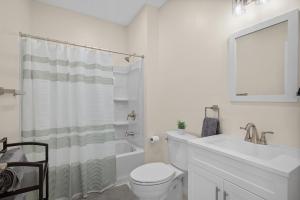 een witte badkamer met een toilet en een wastafel bij Charming Studio with Sun Room Sleeps 4 in Pittsburgh +10 foto's