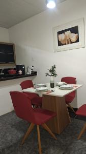 a dining room with a table and red chairs at Apartamento compacto in Macapá