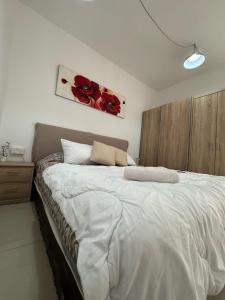a bedroom with a large bed with red flowers on the wall at Elba Apartment in Msida