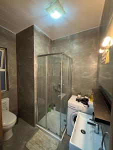 a bathroom with a shower and a washing machine at Elba Apartment in Msida