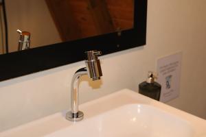 a bathroom sink with a faucet and a mirror at Cabana Amélia, em Gramado in Gramado +20 photos
