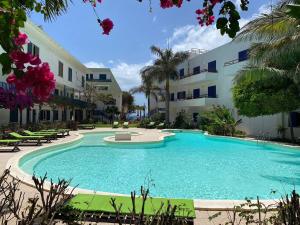 a large swimming pool in front of a building at Leme Bedje Two Bedroom - By Bobbywashere in Santa Maria
