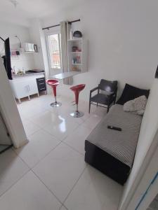 ein Wohnzimmer mit einer Couch und zwei roten Hockern in der Unterkunft ALL liberdade in São Paulo