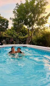two people are swimming in a swimming pool at Mohana in Puerto Colombia