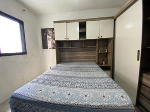 Un dormitorio con una cama grande con cabecero de madera. en Apto 2min da praia Ocian! Perto da Estatua Netuno!, en Samaritá