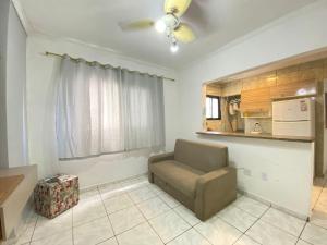 Una sala de estar con un sofá y una cocina. en Apto 2min da praia Ocian! Perto da Estatua Netuno!, en Samaritá