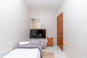 a bedroom with a bed and a tv in it at Centro de BSB - quarto duplo in Brasilia