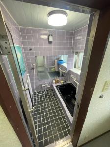 a bathroom with purple tiles and a sink at 白浜荘Shirahamaso in Minamiboso