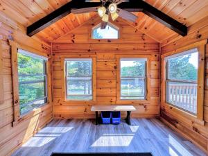 Cabaña de madera con mesa en el medio en BMV6 Tiny Home Topline, en Carroll