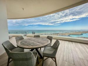 a table and chairs on a balcony with a view of the beach at 3BR Ground Floor Condo with Direct Pool Access #109 in Puerto Peñasco