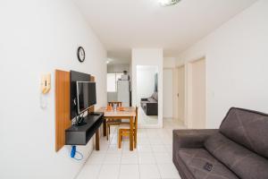 una sala de estar con un sofá y una mesa en Apartamento próximo a BR 101 ideal para viajantes, en Palhoça 11 fotos más