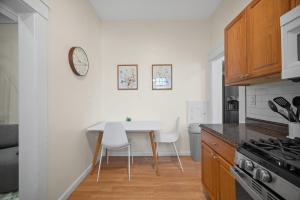 eine Küche mit einem Tisch und Stühlen sowie einer Uhr an der Wand in der Unterkunft Unique Highland Park 2 Bdr Loft Sleeps 5 in Pittsburgh + 15 Fotos