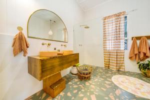 a bathroom with a sink and a mirror at Bangalow Charm - Spacious & stylish - Central Bangalow in Bangalow