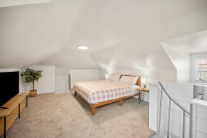 ein weißes Schlafzimmer mit einem Bett und einem Fenster in der Unterkunft Unique Highland Park 2 Bdr Loft Sleeps 5 in Pittsburgh