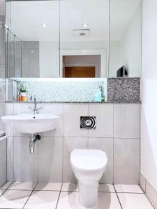 a bathroom with a white toilet and a sink at River View London Eye Vauxhall 2 Bedroom Apartment in London +32 photos