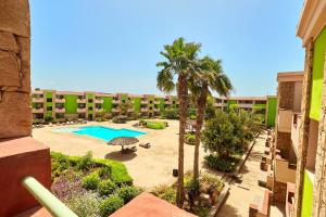 an apartment patio with a swimming pool and palm trees at Djadsal Moradias - by Bobbywashere in Santa Maria