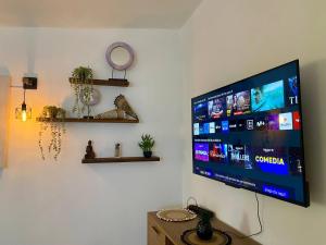 a flat screen tv hanging on a white wall at Djadsal Moradias - by Bobbywashere in Santa Maria +111 photos