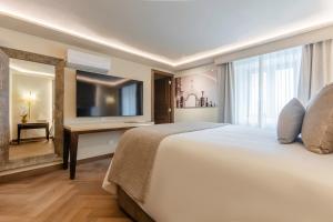 a hotel room with a large bed and a television at Quinta Real Puebla in Puebla