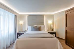 a bedroom with a large white bed and a window at Quinta Real Puebla in Puebla +84 photos