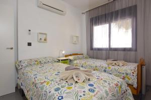two beds with towels on them in a bedroom at Magnifico apartamento en Oasis Beach in Playa Flamenca +23 photos