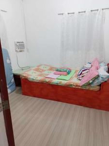 ein kleines Bett in einem Zimmer mit Fenster in der Unterkunft Vincent and Rose Home stay in Maricaban