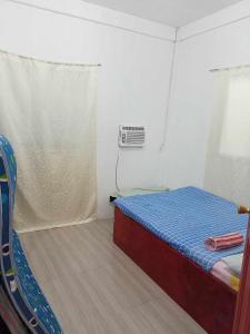 ein kleines Schlafzimmer mit einem Bett und einem Fenster in der Unterkunft Vincent and Rose Home stay in Maricaban + 1 Foto