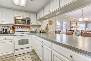 a kitchen with white cabinets and a white stove top oven at Amelia Island View Condo in Fernandina Beach