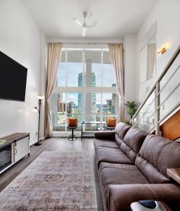 a living room with a couch and a large window at Two-Story Loft with a High-rises view and Rooftop Deck in Vancouver