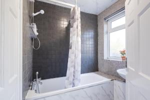 a bathroom with a tub and a shower at Comfy Home-Vimy Road in Birmingham +56 photos