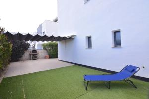 a blue chair in a yard next to a building at Magnifico apartamento en Oasis Beach in Playa Flamenca