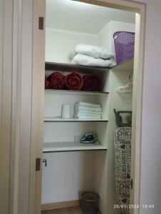 a closet with white shelves with roses in it at Apartamento en San Miguel hermosa vista al mar in Lima