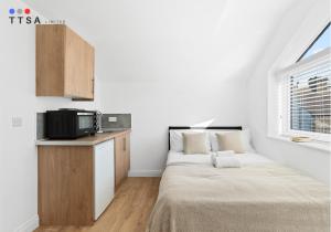 a small bedroom with a bed and a microwave at TTSA - Studio - Norwood Junction - B4 in Norwood