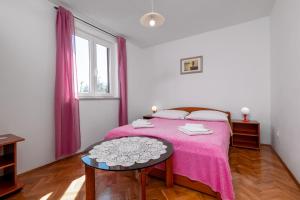 sypialnia z łóżkiem z różowym kocem w obiekcie Apartments with parking spaces Rabac, Labin - 7622 w Rabacu