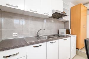 kuchnia z białymi szafkami i zlewem w obiekcie Apartments with parking spaces Rabac, Labin - 7622 w Rabacu +33 zdjęcia
