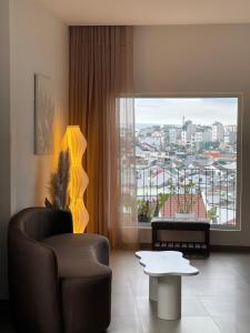 a living room with a couch and a large window at Căn Hộ Đan Mây- Đan Mây Apartment Đà Lạt in Da Lat