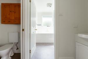 a bathroom with a toilet and a sink at Charming 3-Bedroom Home with Sunroom & Parking in Kings Park +24 photos